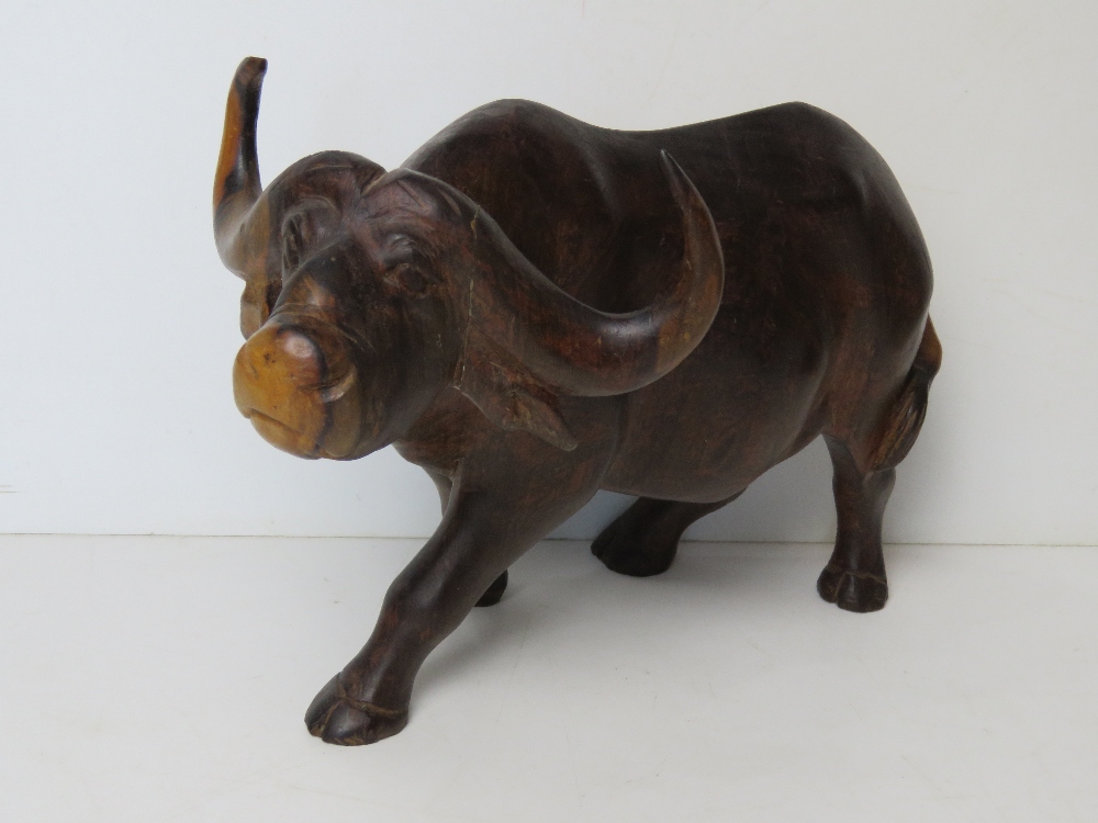 A large hand carved wooden figurine of a water buffalo approx 30cm in length.
