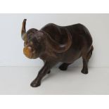 A large hand carved wooden figurine of a water buffalo approx 30cm in length.