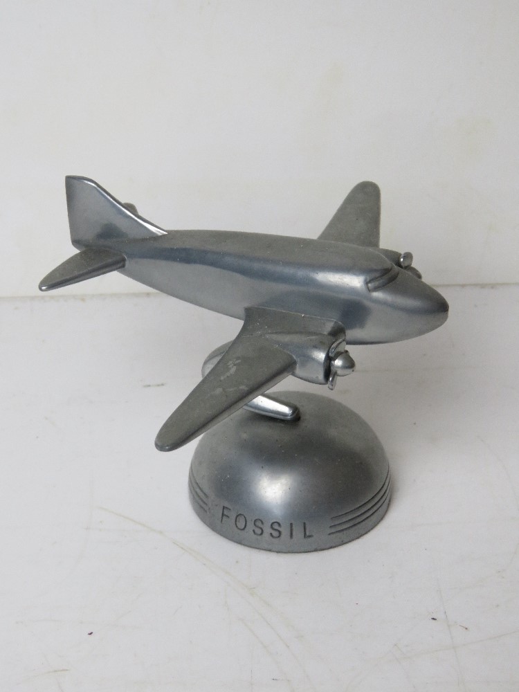 An aeroplane themed rotating desk ornament marked 'Fossil', approx 9.5 x 7cm.