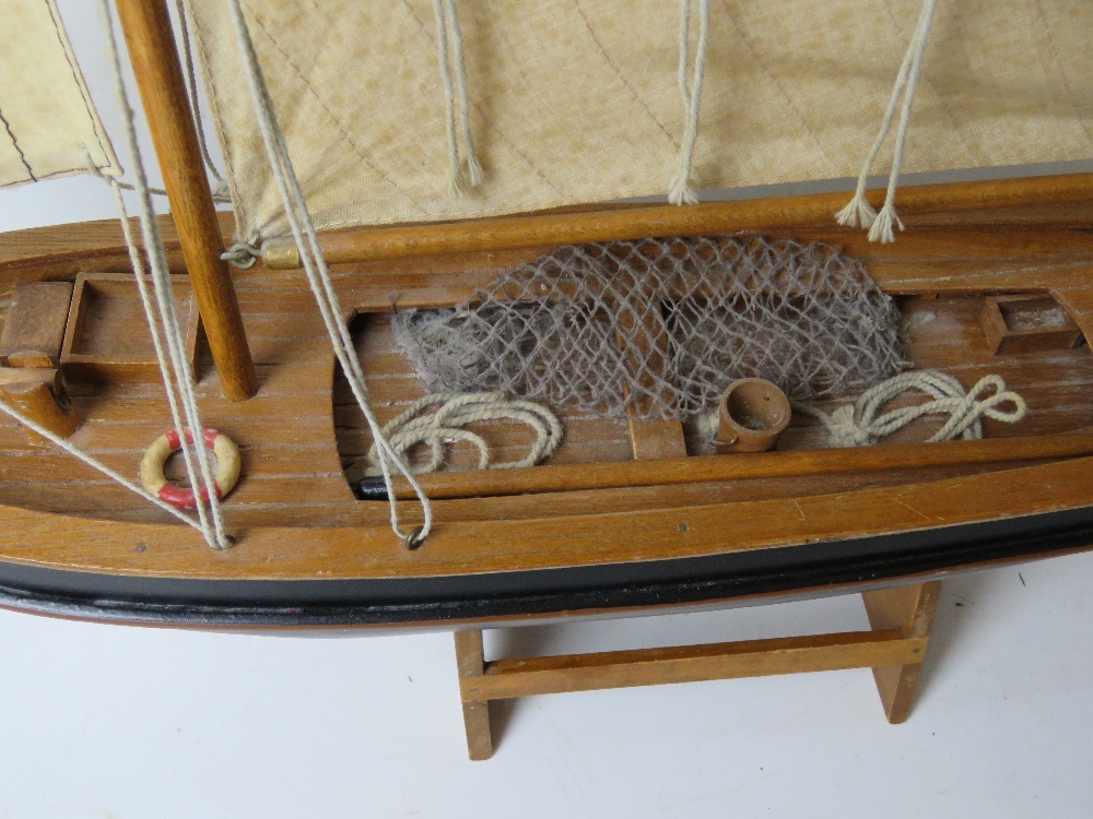 A model fishing boat having painted wooden hull and fabric sales, approx 60cm in length. - Image 2 of 4