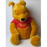 A giant Winnie the Pooh Disney Store cuddly toy, sitting approx 64cm high.