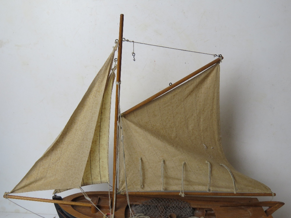 A model fishing boat having painted wooden hull and fabric sales, approx 60cm in length. - Image 3 of 4