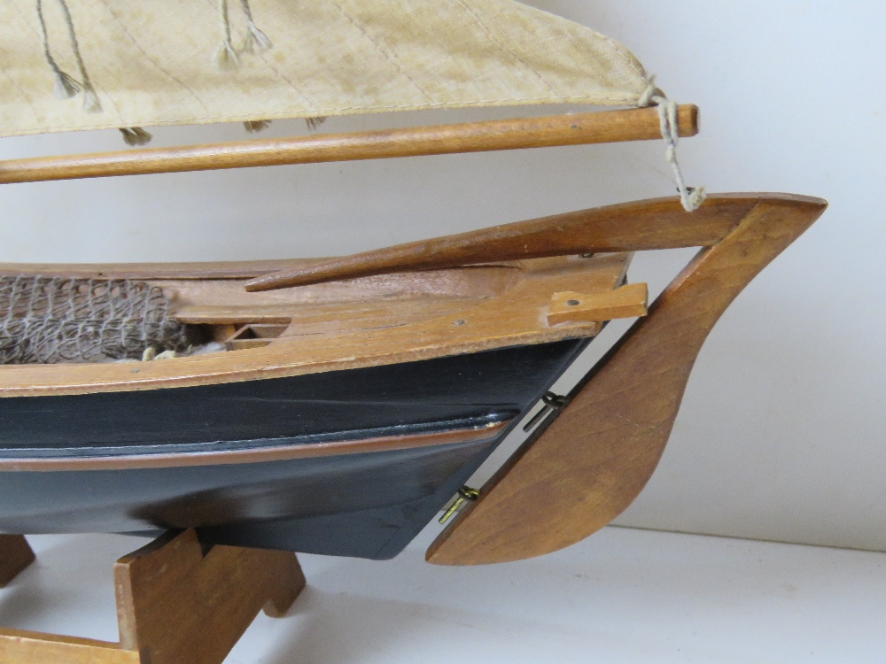 A model fishing boat having painted wooden hull and fabric sales, approx 60cm in length. - Image 4 of 4