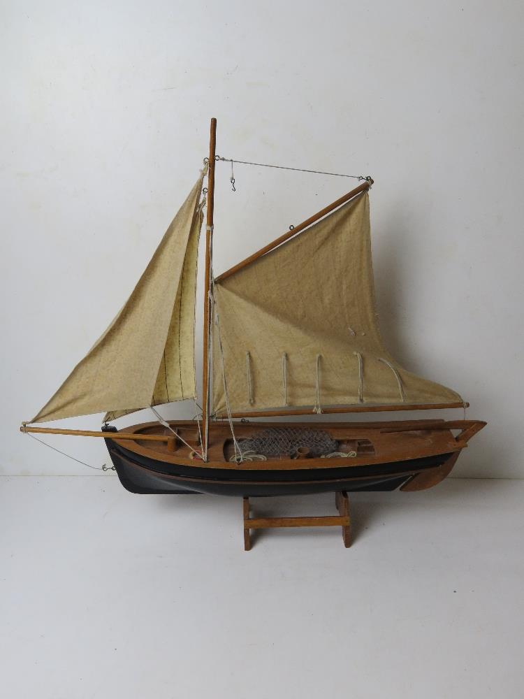 A model fishing boat having painted wooden hull and fabric sales, approx 60cm in length.