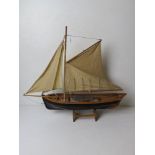 A model fishing boat having painted wooden hull and fabric sales, approx 60cm in length.