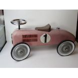 A metal children's ride-on racing car, one bracket a/f, approx 70cm in length.