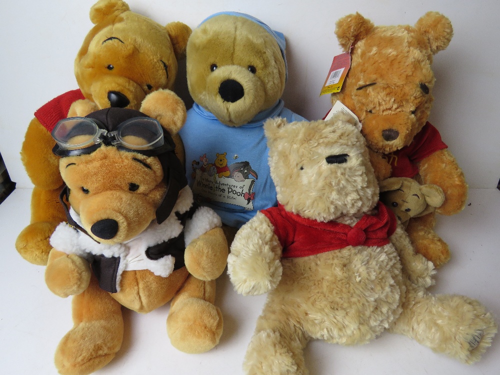 Five assorted Disney Winnie the Pooh cuddly toys.