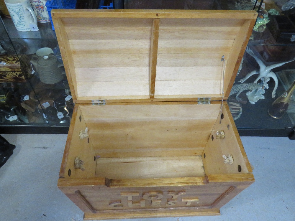 A wooden toy chest having rope end handles and domed lid, hinge a/f, approx 73cm wide. - Image 3 of 3