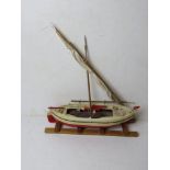 A model of a sailboat with oars, mast a/f, approx 35cm in length.