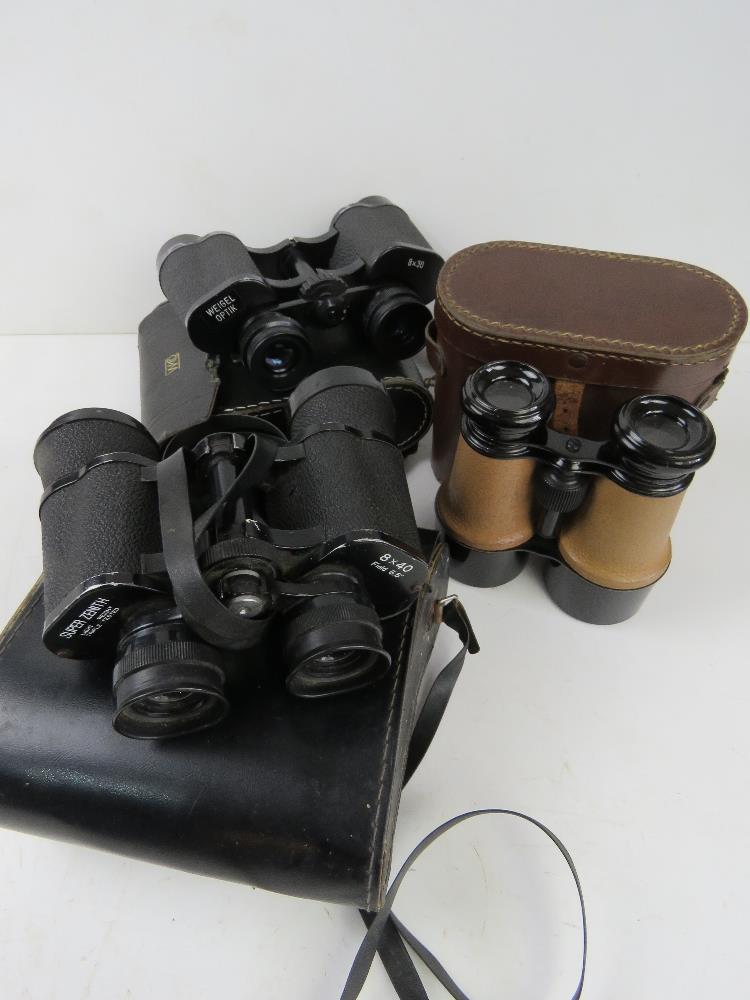 Three binoculars all in cases, being Wei