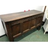 AN EARLY 18th C. OAK COFFER CARVED WITH SCROLL AND FLOWER HEAD BAND ABOVE THE FOUR PANELS TO THE