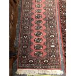 TWO ORIENTAL SMALL RUNNERS OF BOKHARA DESIGN. 191 x 64, 184 x 63cms (2)