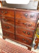 A GEORGE III MAHOGANY CUPBOARD, THE TWO DOORS MODELLED AS BANKS OF FOUR DRAWERS ENCLOSING SHELVES