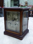 A GLAZED MAHOGANY CASED WINTERHALDER AND HOFMEIER CLOCK CHIMING ON COILED RODS, THE SILVERED DIAL