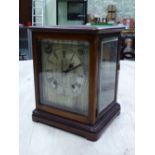 A GLAZED MAHOGANY CASED WINTERHALDER AND HOFMEIER CLOCK CHIMING ON COILED RODS, THE SILVERED DIAL