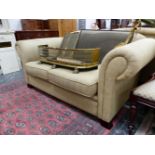 A TWO SEAT SETTEE UPHOLSTERED IN BEIGE HERRING BONE MATERIAL AND ON MAHGOANY LEGS. W 173cms.