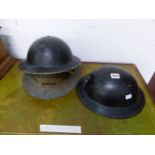 THREE VINTAGE MILITARY TIN HATS.