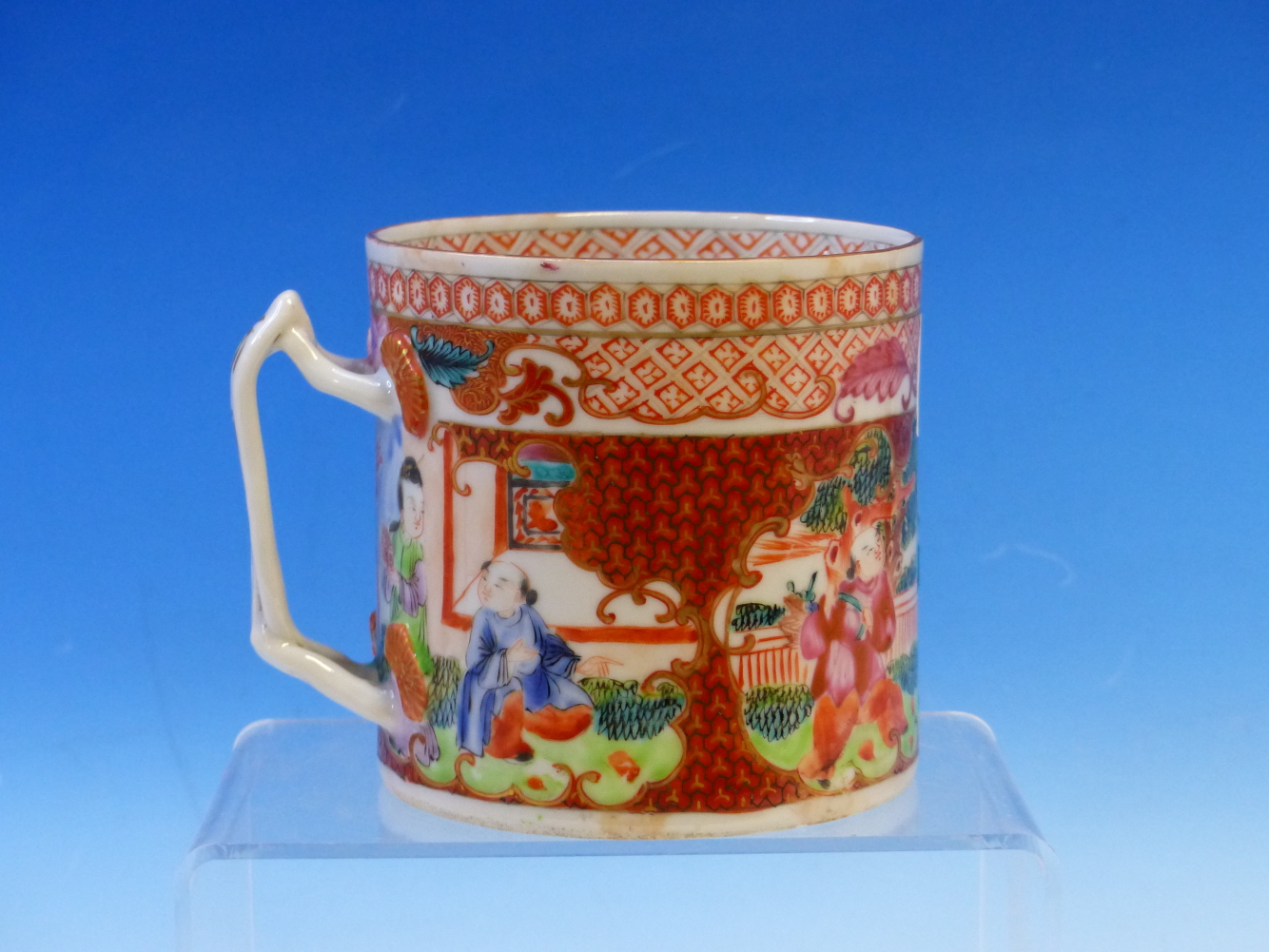 A CHINESE MANDARIN PALETTE MUG PAINTED WITH TWO RESERVES OF FIGURES ON AN IRON RED Y-DIAPER