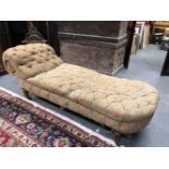 A VICTORIAN CHAISE LONGUE WITH BUTTONED BACK AND ON TURNED MAHOGANY LEGS WITH CASTER FEET. W 190cm