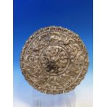 AN EMBOSSED WHITE METAL ROUNDEL, POSSIBLY PART OF A LATIN AMERICAN RELIQUARY, WITH STIPPLE