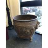 A CHINESE CAST IRON RING HANDLED CAULDRON, THE ROUNDED SIDES CAST WITH FIGURES AND INSCRIPTIONS