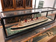 A SCALE MODEL OF THE PASSENGER SHIP THE QUEEN MARY IN A GLAZED EBONISED CASE W 96.5cms.