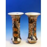 A PAIR OF IMARI STYLE WAISTED CYLINDRICAL VASES PAINTED WITH GARDEN PANELS, PINE AND FLOWERING