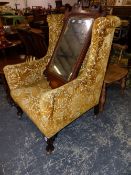 A WING ARMCHAIR UPHOLSTERED IN GOLDEN VELVET DAMASK AND ON MAHOGANY CABRIOLE LEGS WITH CASTER FEET