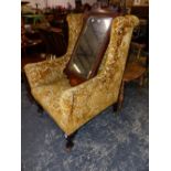 A WING ARMCHAIR UPHOLSTERED IN GOLDEN VELVET DAMASK AND ON MAHOGANY CABRIOLE LEGS WITH CASTER FEET