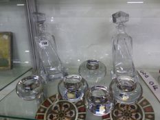 A PAIR OF DECANTERS, AND FIVE KENNETH TURNER TEA LIGHT HOLDERS.
