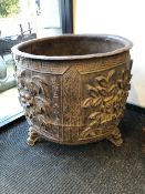 A CHINESE CAST IRON CAULDRON, THE ROUNDED SIDES CAST WITH FOUR PANELS OF FLOWERS ABOVE THREE MASK