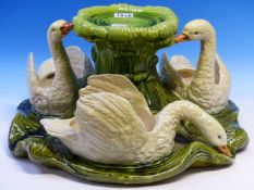 A BRETBY POTTERY TABLE CENTRE PIECE MODELLED AS THREE SWAN FORM BOWLS SWIMMING ON A GREEN BASE ABOUT