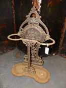 A VICTORIAN FALKIRK IRON STICK STAND CAST WITH A HANDLE ABOVE A FLORAL ROUNDEL AT THE TOP OF THE