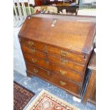 A GEORGE III OAK BUREAU, THE COMPARTMENT UNDER THE FALL ABOVE TWO SHORT AND TWO GRADED LONG