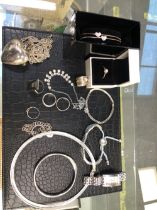 A COLLECTION OF JEWELLERY TO INCLUDE SEVEN VARIOUS SILVER RINGS, A SILVER CHARM BRACELET, AND