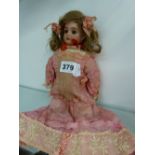 AN ANTIQUE BISQUE HEAD DOLL UNSIGNED.