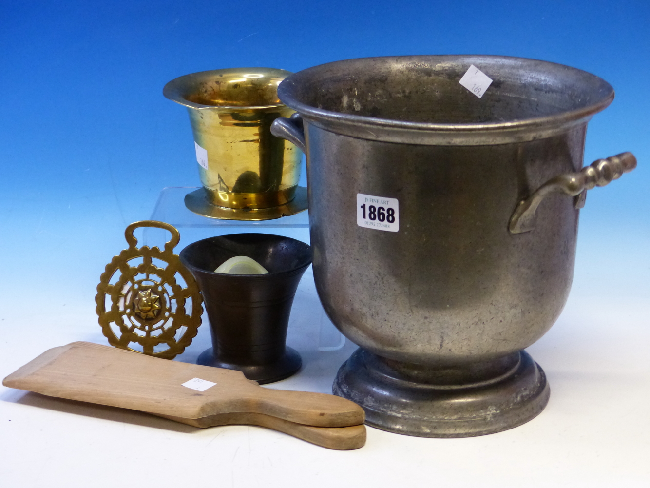 A PEWTER TWO HANDLED WINE BUCKET. H 23cms. A HORSE BRASS, A PAIR OF WOODEN BUTTER PADDLES AND TWO