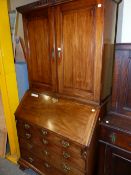 A GEORGE III MAHOGANY BUREAU BOOKCASE, THE DENTIL CORNICE OVER PANELLED DOORS, THE FALL AND FOUR