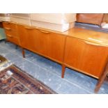 A 20th C. SCANDINAVIAN TASTE TEAK SIDE BOARD, THE CENTRAL CUPBOARD FLANKED BY THREE DRAWERS AND A