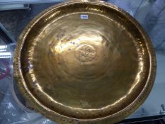 AN ARTS AND CRAFTS BRASS DISH BY PHILIP FREDERICK ALEXANDER WITH CENTRAL CHRISTIAN CYPHER WITHIN