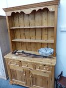 A MODERN PINE DRESSER. THE ENCLOSED TWO SHELF BACK OVER THREE DRAWERS AND TWO DOORS TO THE BASE. W