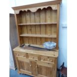 A MODERN PINE DRESSER. THE ENCLOSED TWO SHELF BACK OVER THREE DRAWERS AND TWO DOORS TO THE BASE. W