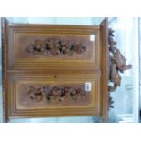 A BLACK FOREST FRUIT WOOD WALL HANGING FRAME FOR TWELVE PICTURES ENCLOSED BY DOORS CARVED IN