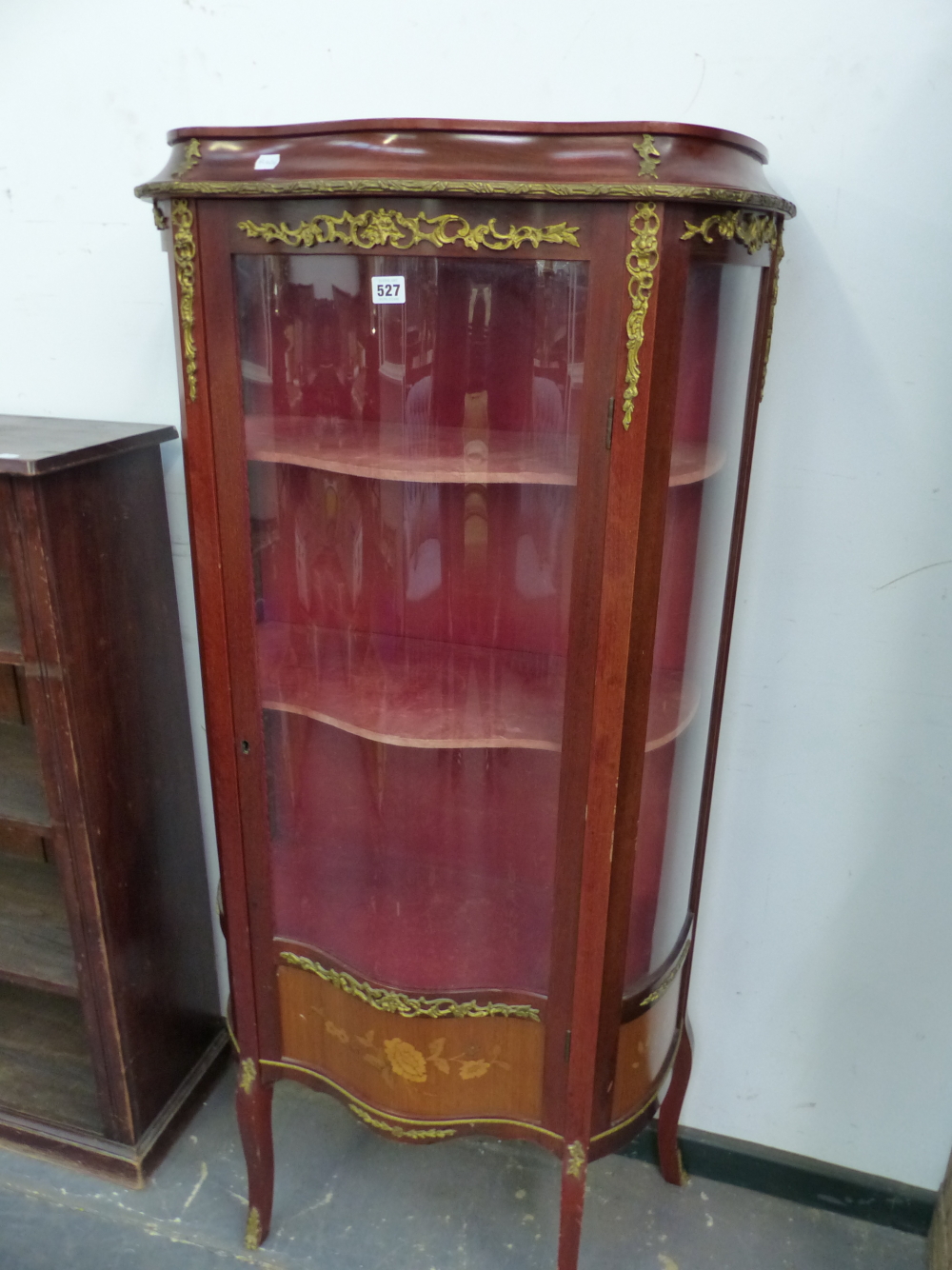 A 20th C. FRENCH MAHOGANY DISPLAY CABINET, ORMOLU MOUNTED ABOUT THE SERPENTINE GLAZED DOOR ENCLOSING