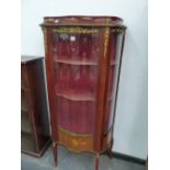 A 20th C. FRENCH MAHOGANY DISPLAY CABINET, ORMOLU MOUNTED ABOUT THE SERPENTINE GLAZED DOOR ENCLOSING