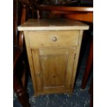 A PINE BEDSIDE CUPBOARD WITH A DRAWER OVER A DOOR. H 64.5cms.