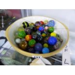 A LARGE BOWL OF DECORATIVE MARBLES.