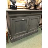 A 19th C. FRENCH GREY PAINTED SIDE CABINET WITH A SHAPED DRAWER OVER PANELLED DOORS AND PLINTH FOOT.