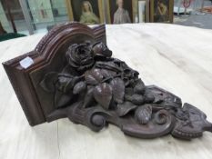 A VICTORIAN PIERCED AND CARVED OAK WALL BRACKET, THE SHELF ABOVE A SCROLLING SHIELD SHAPE WITH ROSES