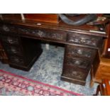 A LATE VICTORIAN OAK PEDESTAL DESK, THE BROWN LEATHER INSET TOP OF A KNEEHOLE DRAWER FLANKED BY